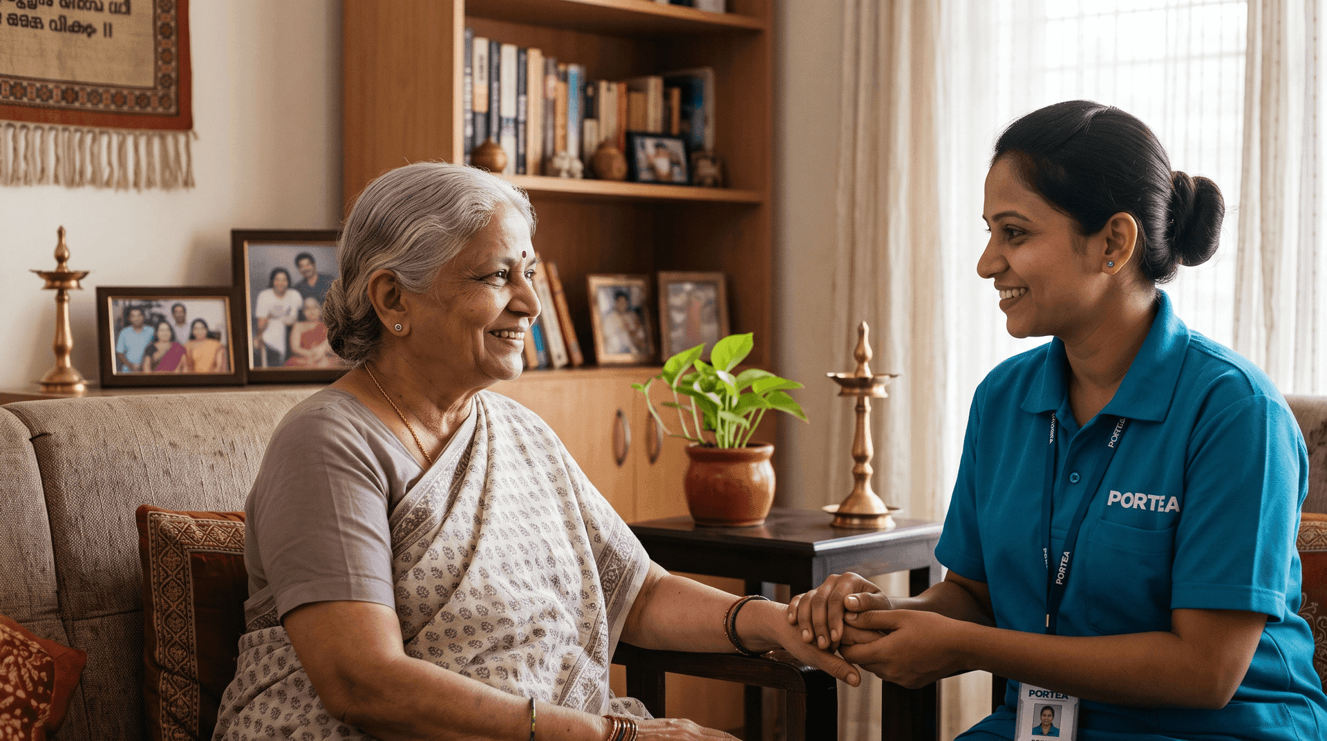 A Portea caregiver in uniform sitting with a smiling elderly woman at home